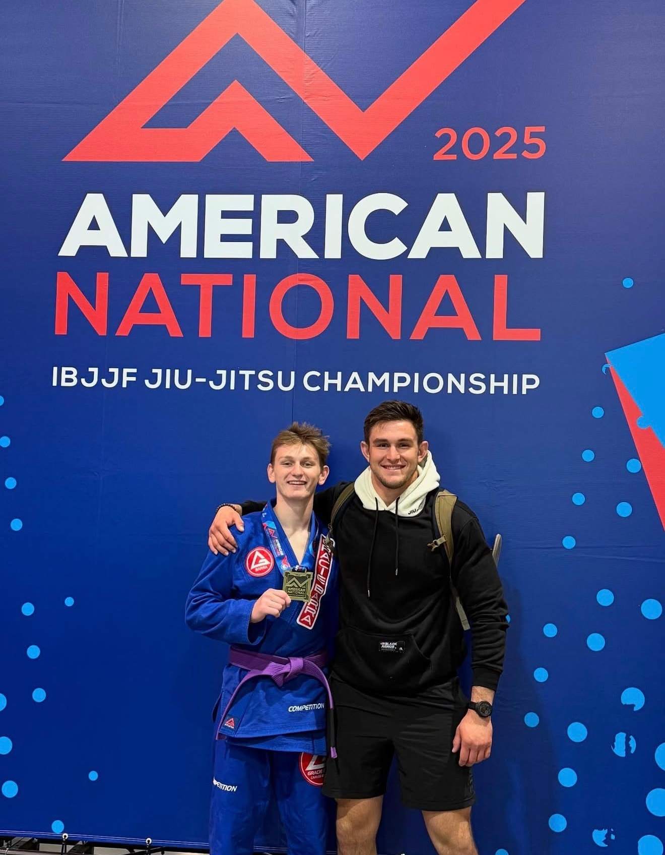 A teenage purple belt with his medal and his coach at the 2025 IBJJF American National Championship